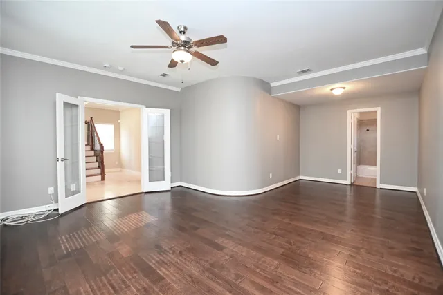 a view of an empty room with window and wooden floor