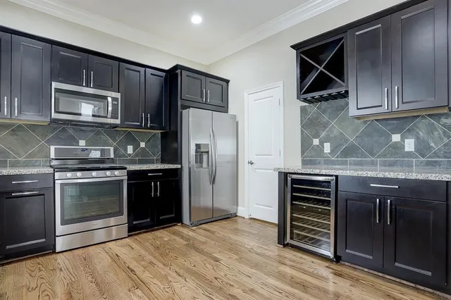 a kitchen with granite countertop a refrigerator and cabinets