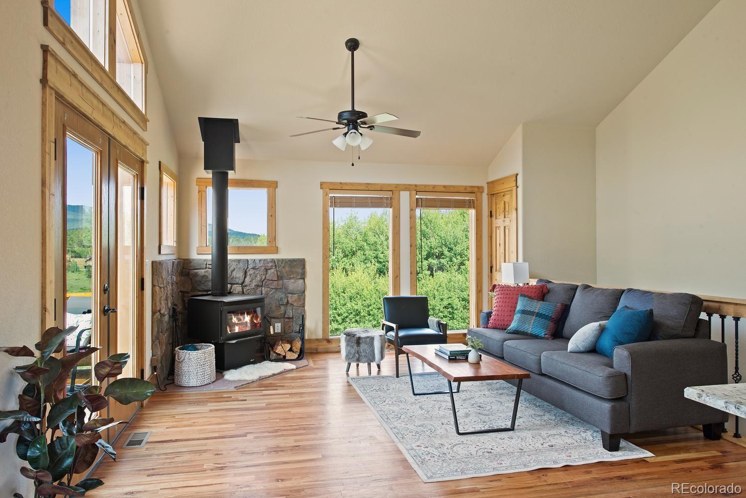 1328 Clark Road Bailey, CO 80421 - Photo 11 of 37 a living room with furniture fireplace and a large window