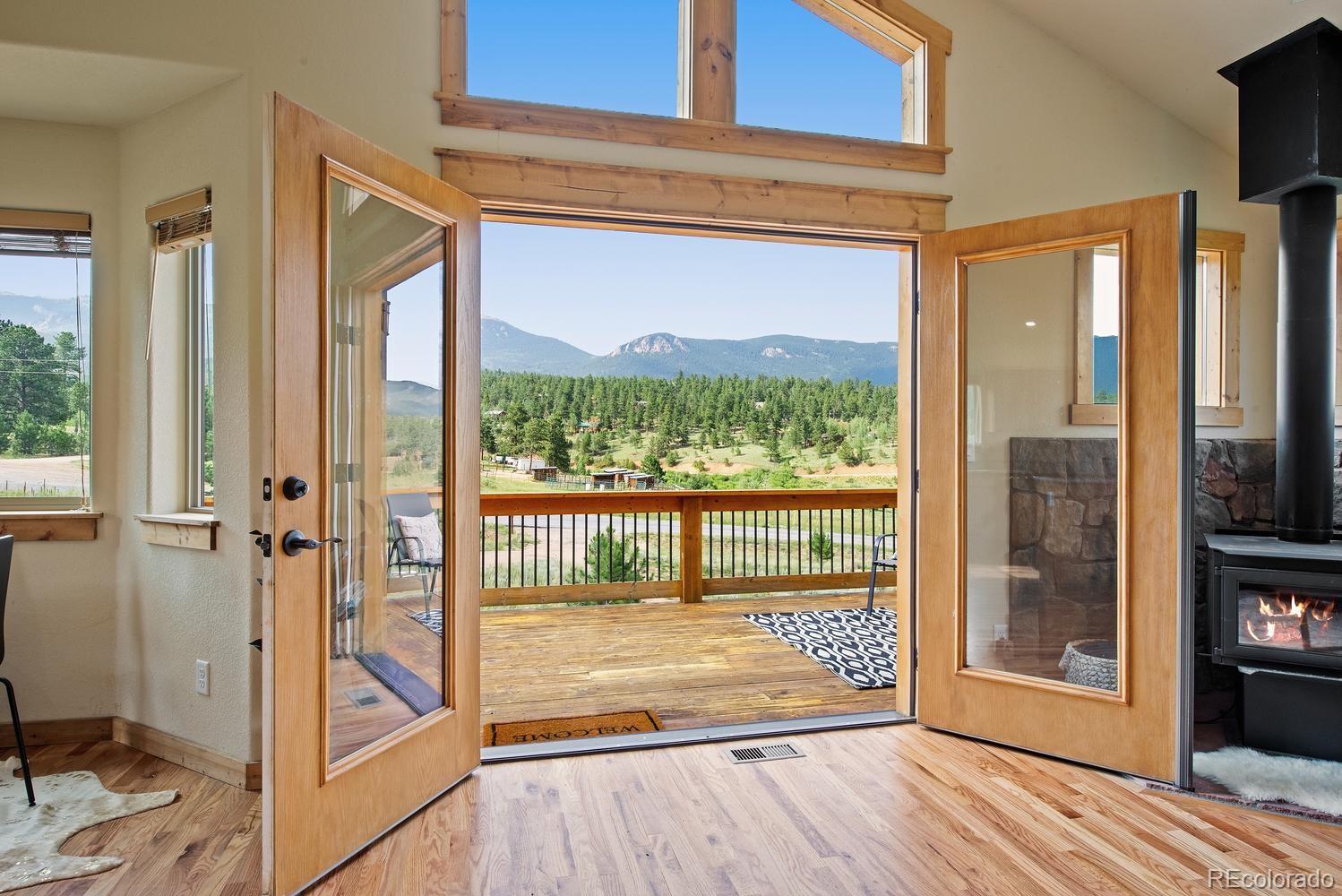 1328 Clark Road Bailey, CO 80421 - Photo 12 of 37 a view of a room with wooden floor and a floor to ceiling window