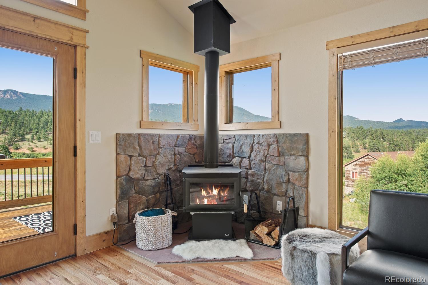 1328 Clark Road Bailey, CO 80421 - Photo 15 of 37 a living room with furniture and a fireplace