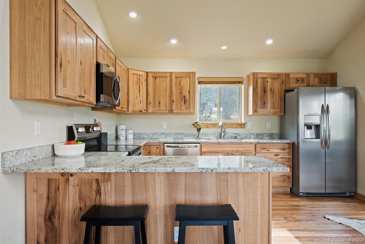 1328 Clark Road Bailey, CO 80421 - Photo 19 of 37 a kitchen with refrigerator a stove a sink and a cabinets