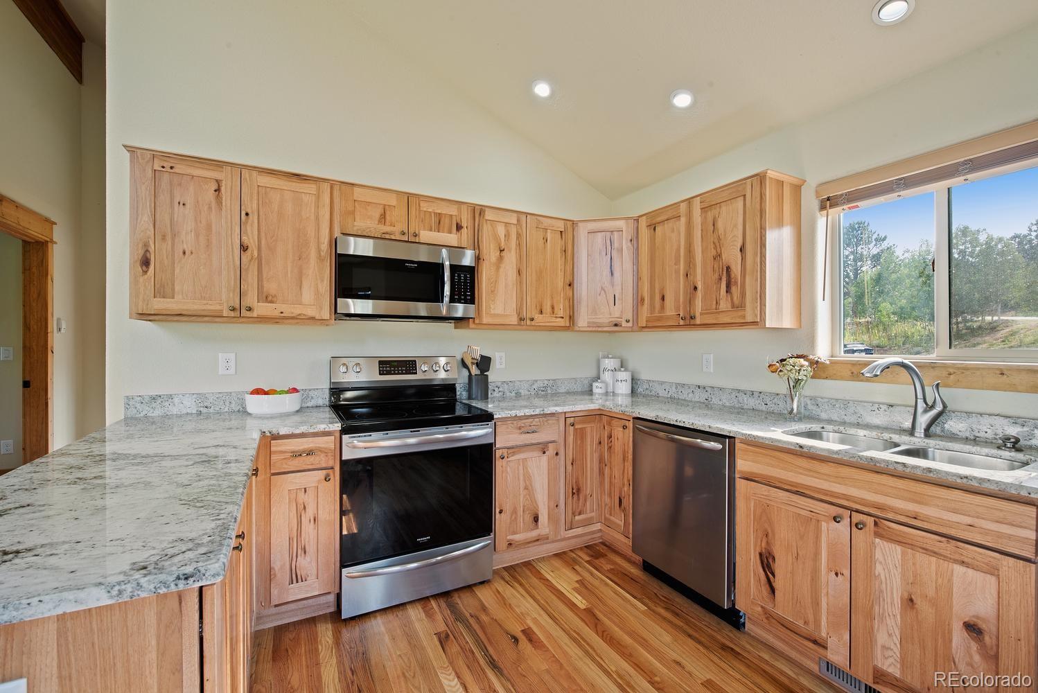 1328 Clark Road Bailey, CO 80421 - Photo 24 of 37 a kitchen with stainless steel appliances granite countertop a stove a sink and a microwave