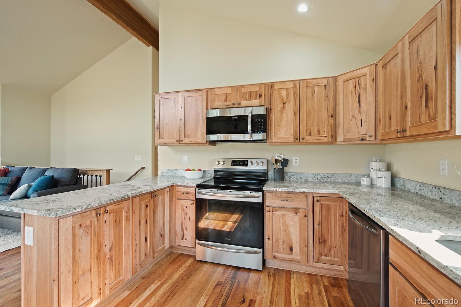 1328 Clark Road Bailey, CO 80421 - Photo 25 of 37 a kitchen with stainless steel appliances granite countertop a stove top oven a sink dishwasher and cabinets with wooden floor