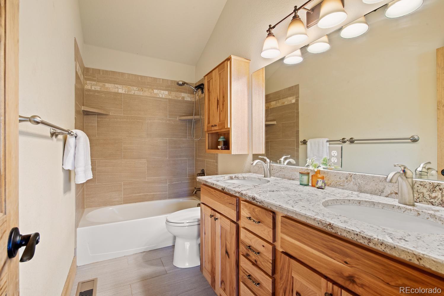 1328 Clark Road Bailey, CO 80421 - Photo 28 of 37 a bathroom with a granite countertop sink a toilet and a bathtub