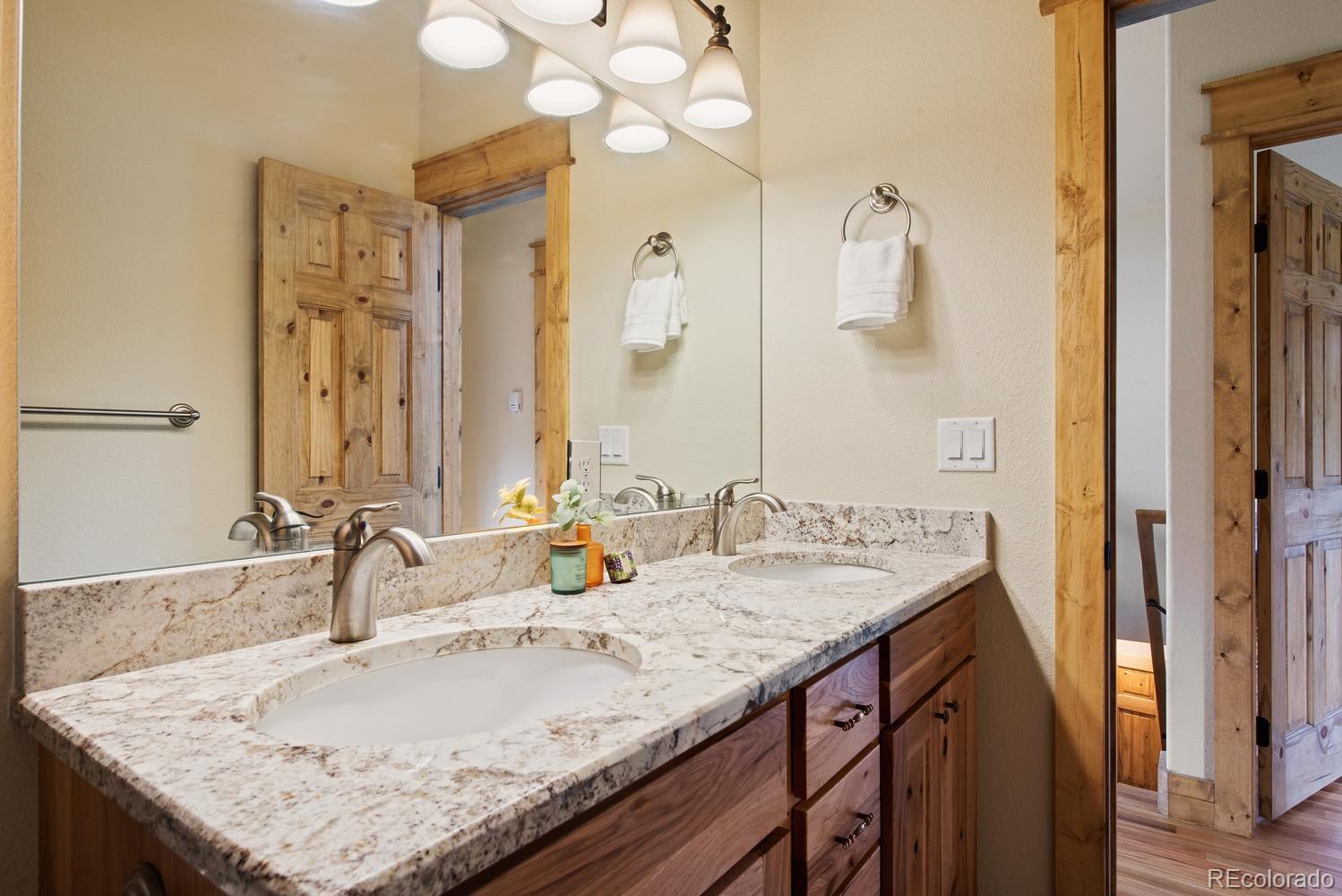 1328 Clark Road Bailey, CO 80421 - Photo 29 of 37 a bathroom with a granite countertop sink and a mirror