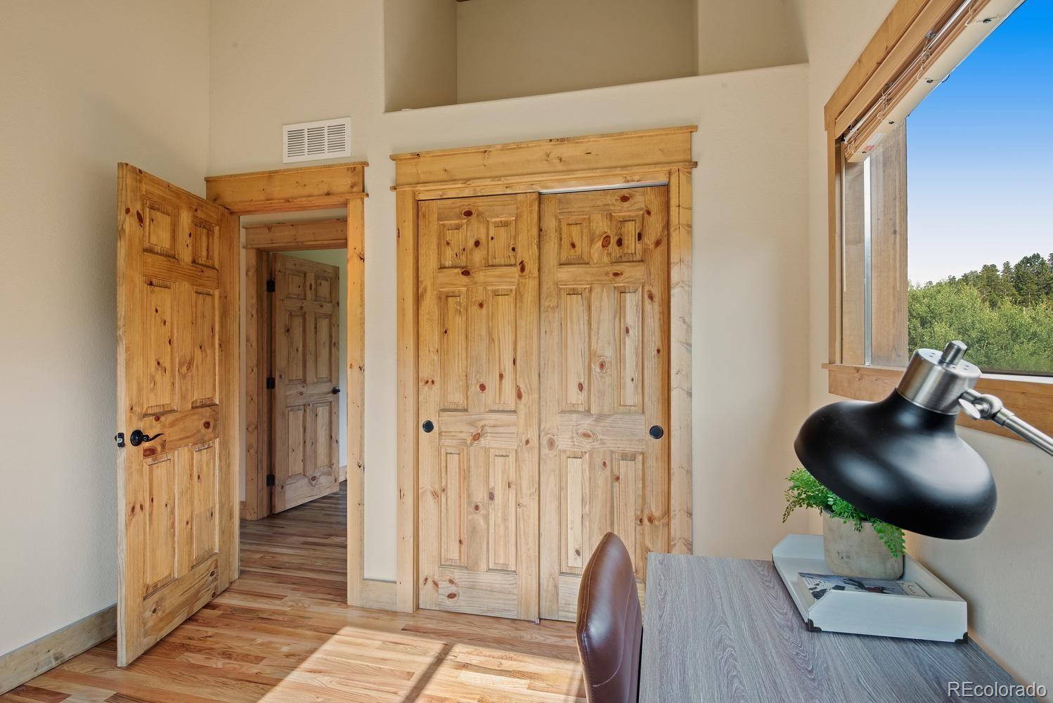 1328 Clark Road Bailey, CO 80421 - Photo 32 of 37 a living room with furniture and a wooden floor