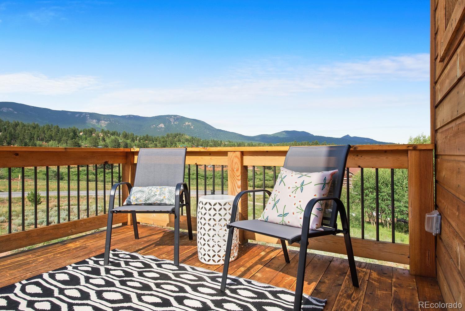 1328 Clark Road Bailey, CO 80421 - Photo 8 of 37 a view of a chairs and table on wooden deck with lake view