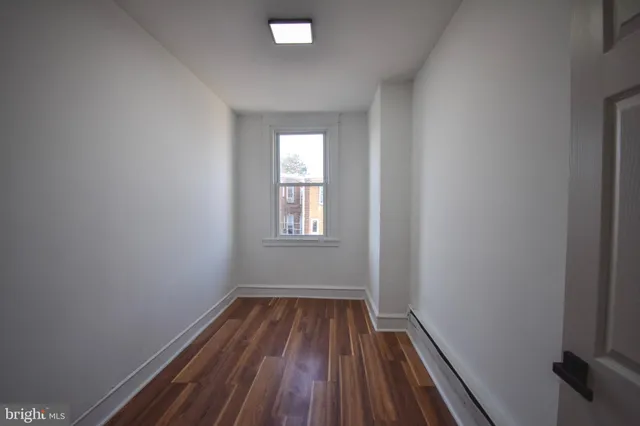 a view of a room with wooden floor and window