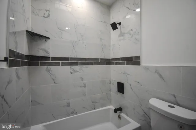 a bathroom with a shower a toilet and a sink