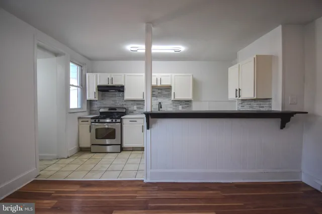 a kitchen with granite countertop a sink cabinets and stainless steel appliances