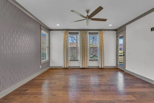 an empty room with wooden floor and windows