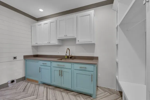 a kitchen with stainless steel appliances granite countertop a sink and cabinets with wooden floor