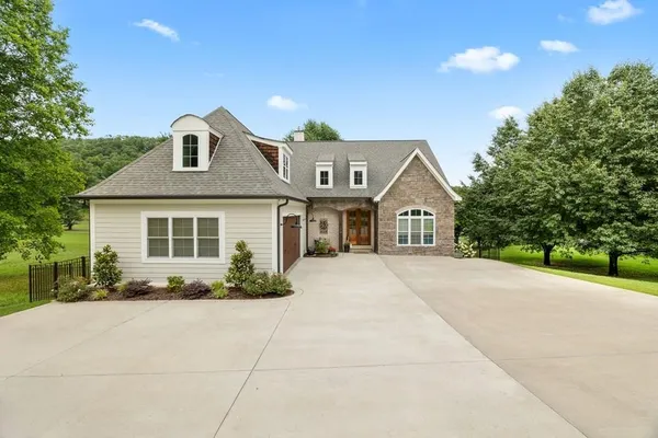 a front view of a house with yard and green space