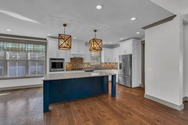 a kitchen with stainless steel appliances granite countertop a stove and a refrigerator
