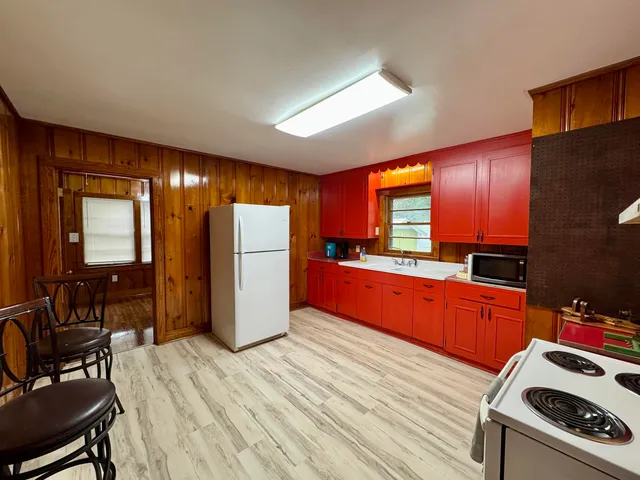 a kitchen with stainless steel appliances granite countertop wooden cabinets a refrigerator and a stove