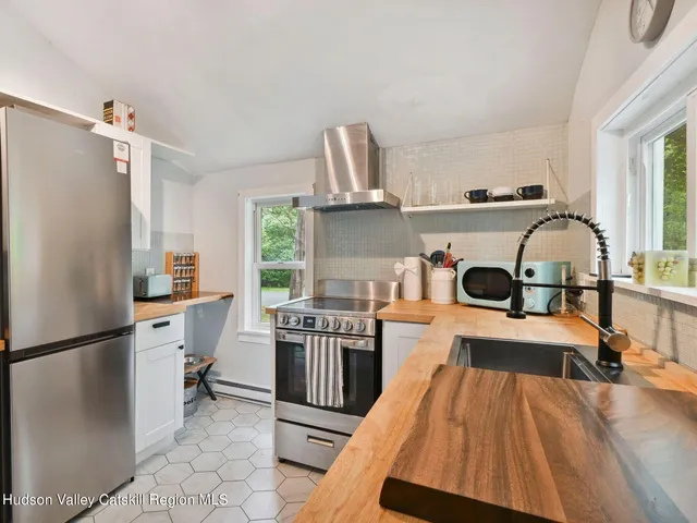 a kitchen with a stove a refrigerator and a stove top oven