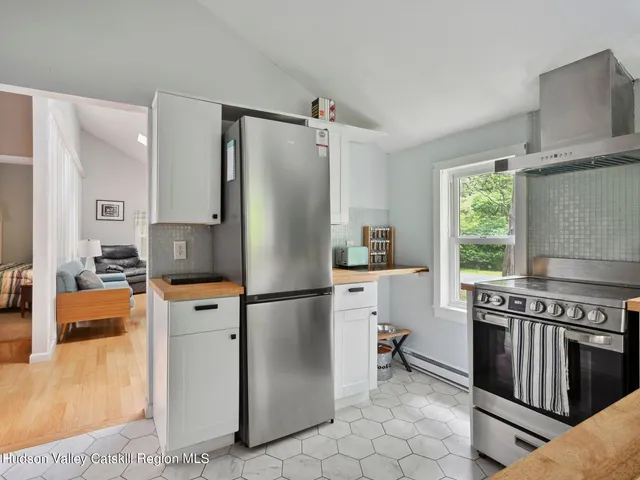 a kitchen with white cabinets and a refrigerator