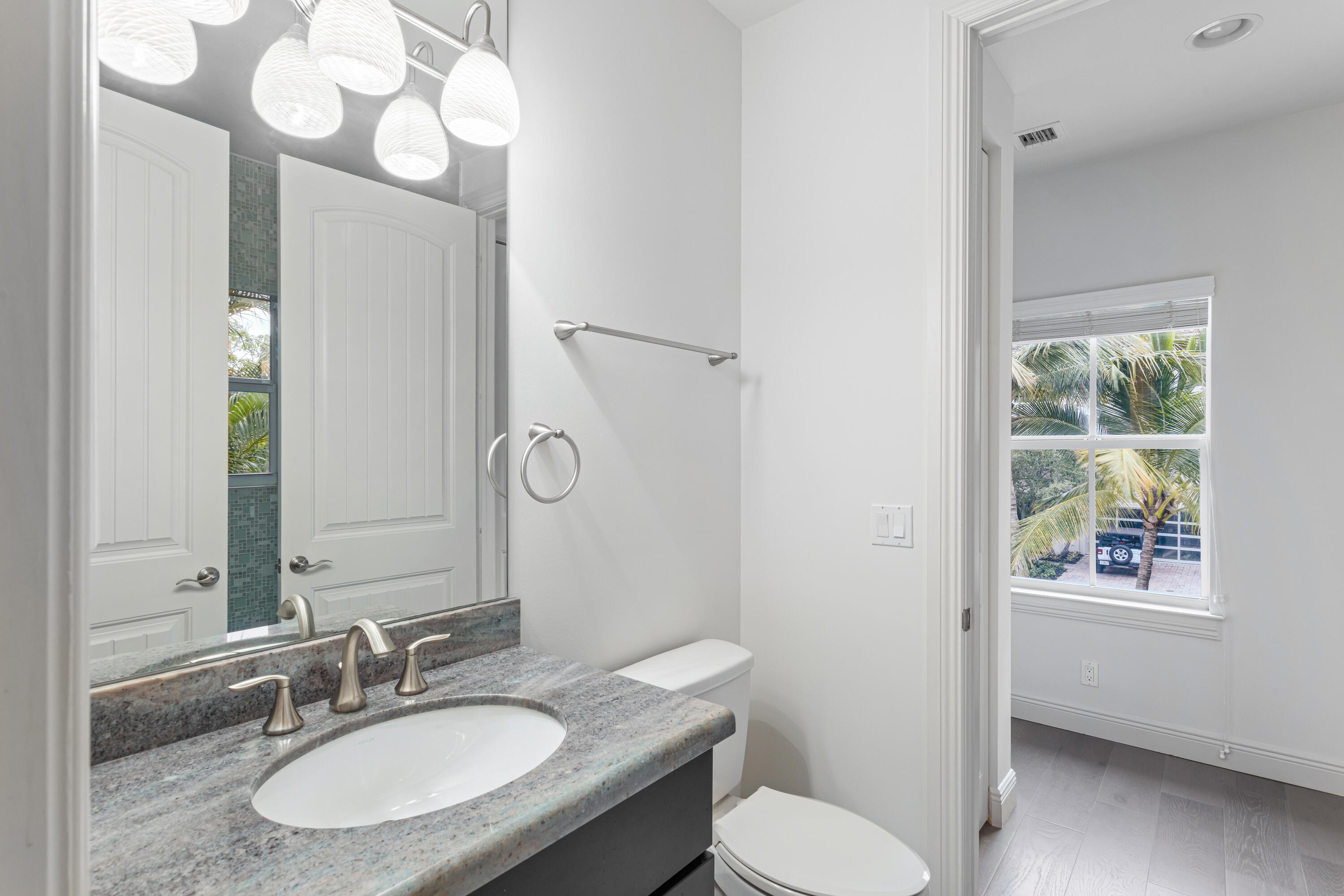 391 East Boca Raton Road Boca Raton, FL 33432 - Photo 23 of 26 a bathroom with a granite countertop toilet sink and mirror