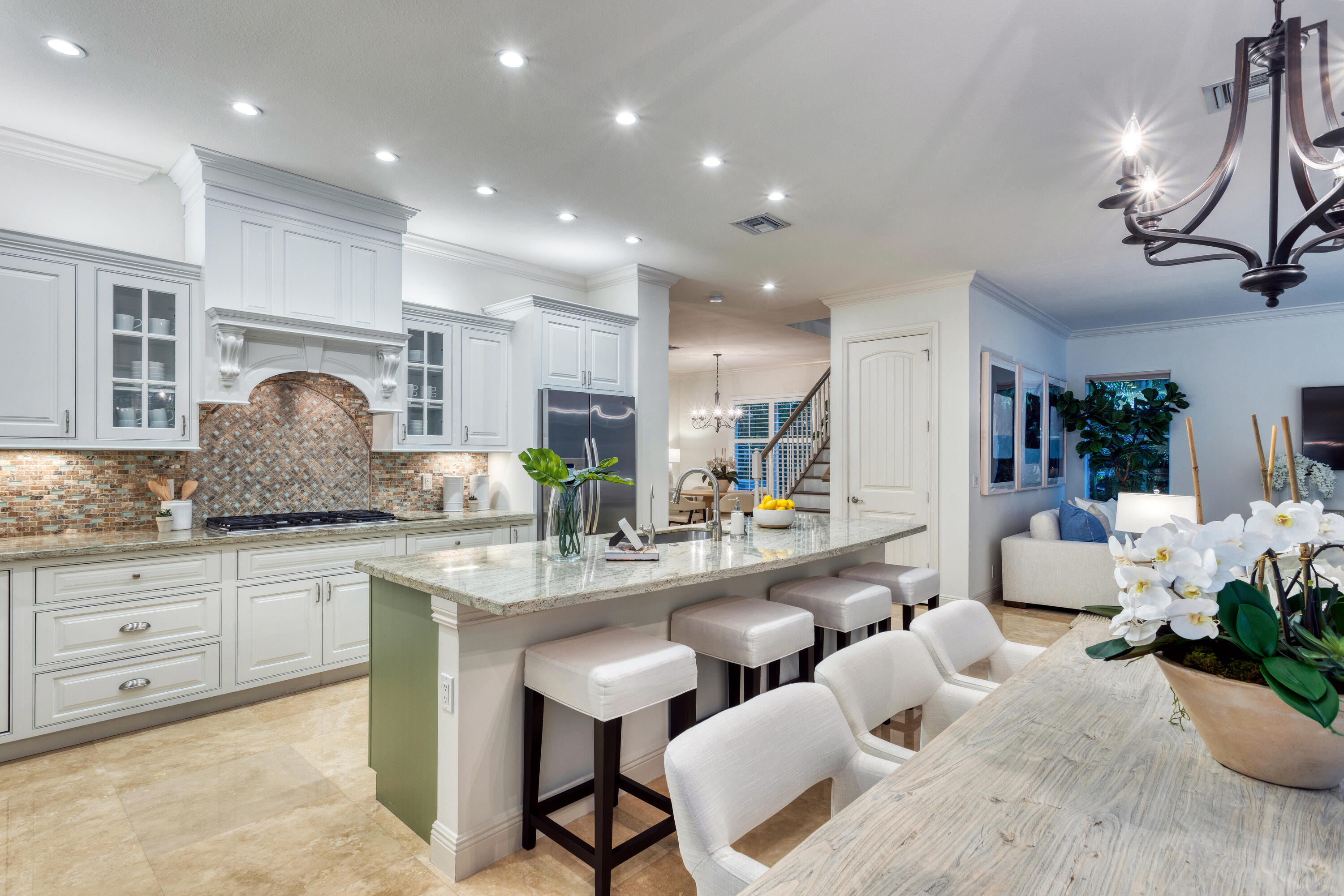 391 East Boca Raton Road Boca Raton, FL 33432 - Photo 7 of 26 a kitchen with granite countertop white cabinets and chairs