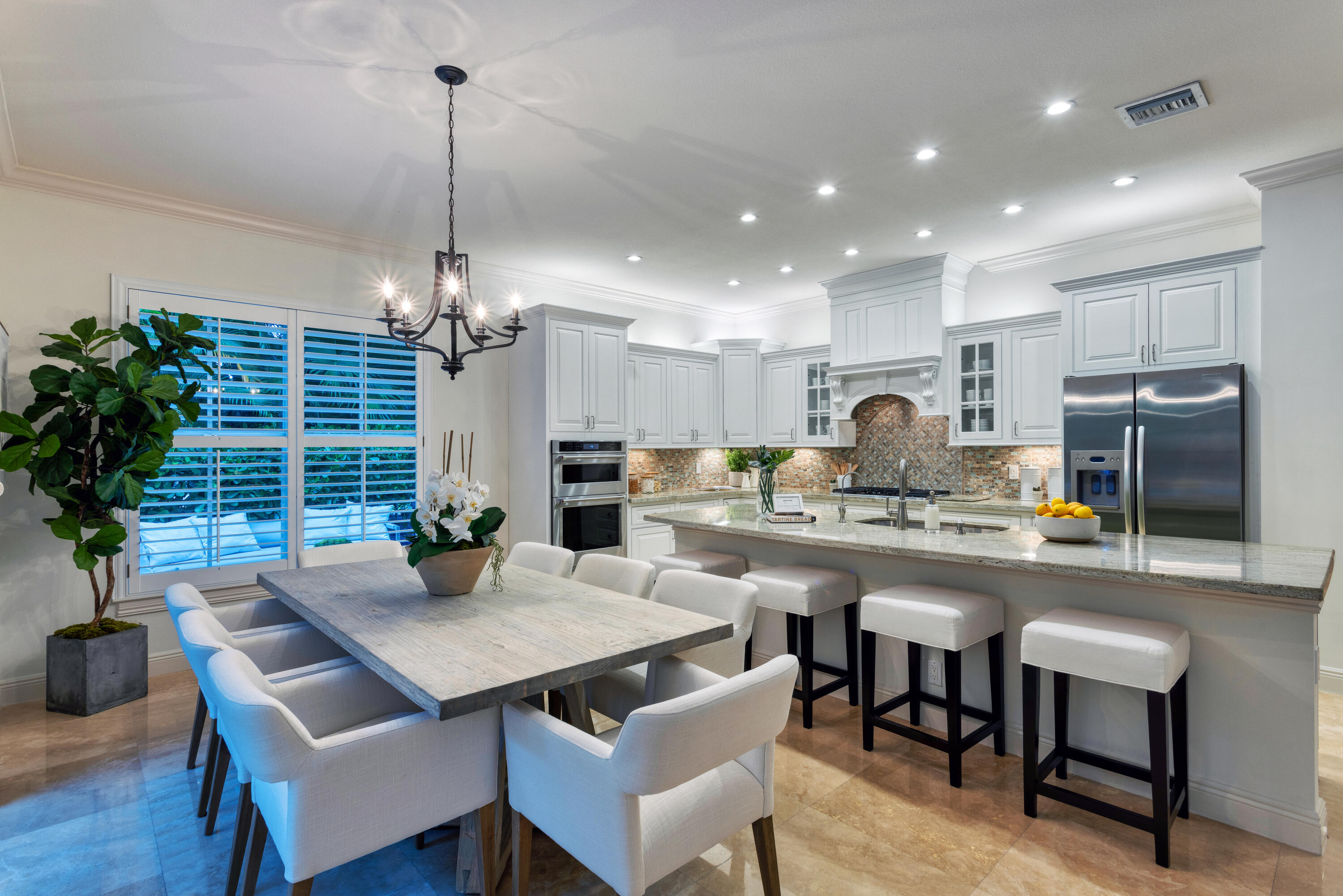 391 East Boca Raton Road Boca Raton, FL 33432 - Photo 9 of 26 a kitchen with a table chairs refrigerator and cabinets