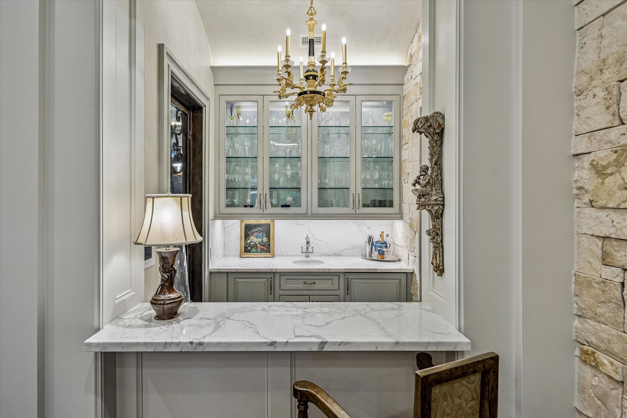 2158 Chilton Road Houston, TX 77019 - Photo 21 of 50 Ideally positioned between the main living spaces, the wet bar features marble countertops, glass-front cabinetry, and premium appliances including a SubZero beverage refrigerator and ice maker. Designed for effortless entertaining, it serves as a stylish and functional hub.