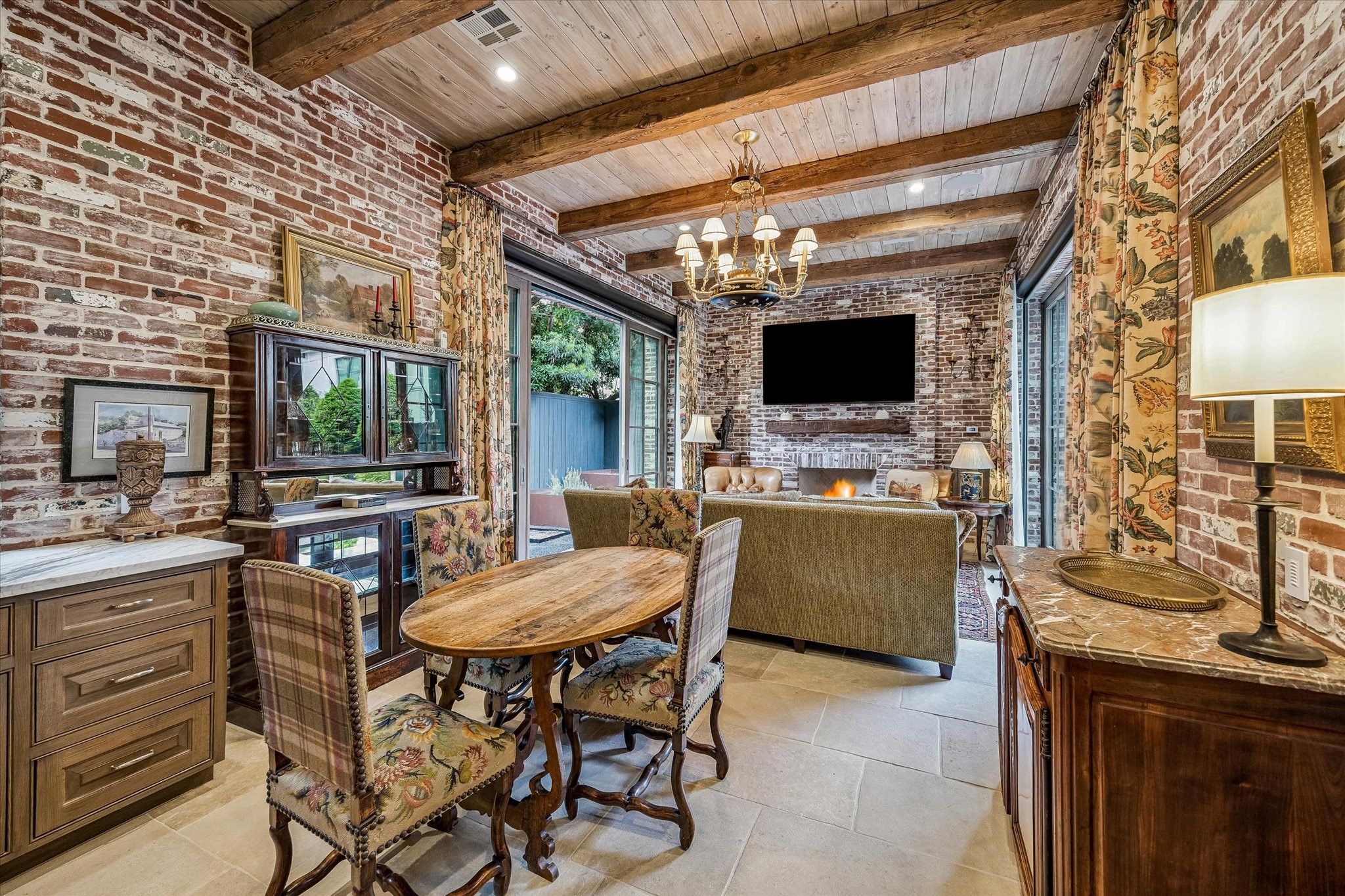 2158 Chilton Road Houston, TX 77019 - Photo 23 of 50 The Four Seasons room is a true extension of the home, blending indoor comfort with outdoor living through walls of windows overlooking the pool and herb garden. Featuring a fireplace, full summer kitchen, and beamed ceiling, it’s designed for year-round enjoyment.