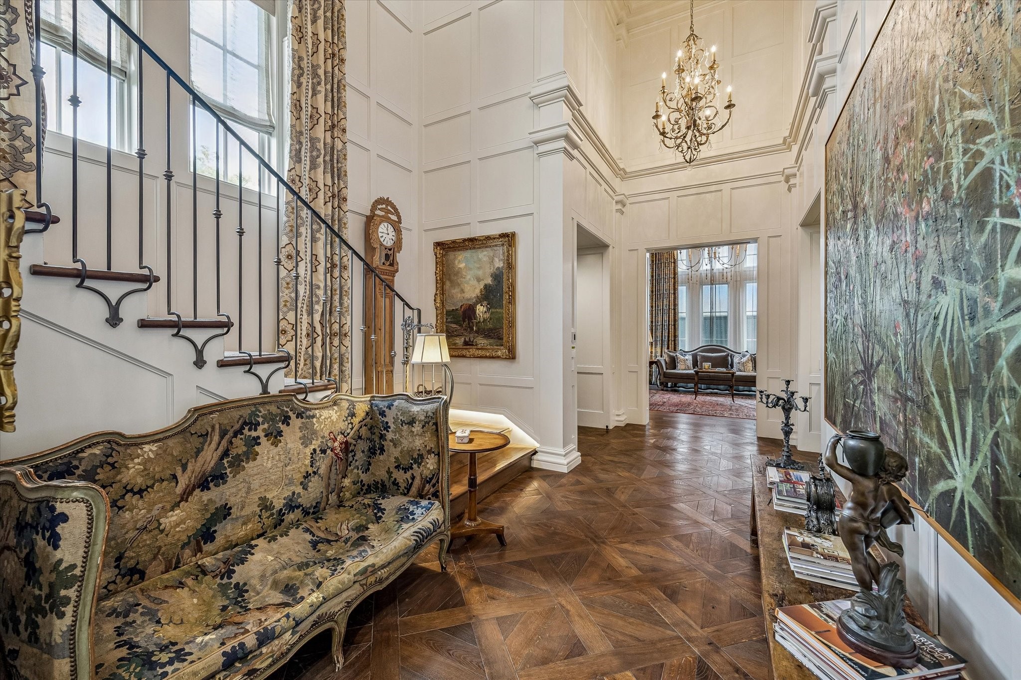 2158 Chilton Road Houston, TX 77019 - Photo 28 of 50 The stunning foyer features Versailles parquet hardwood floors, double-height ceilings, and a designer chandelier that sets an elegant tone upon entry. Cased openings lead to the formal living room, family room, and library, while a custom staircase and Inclinator elevator provide graceful access to the upper floors.