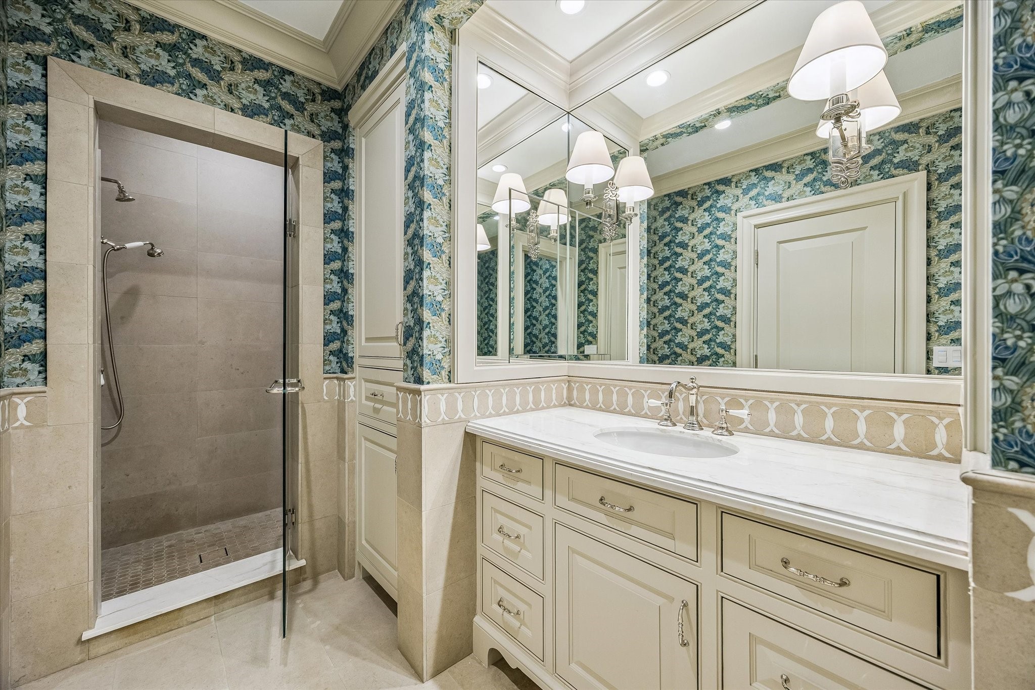 2158 Chilton Road Houston, TX 77019 - Photo 37 of 50 The ensuite bathroom features marble countertops, a walk-in shower with bench seating, and Rohl polished nickel hardware. Designer wallcovering and crown molding create a sophisticated guest space.