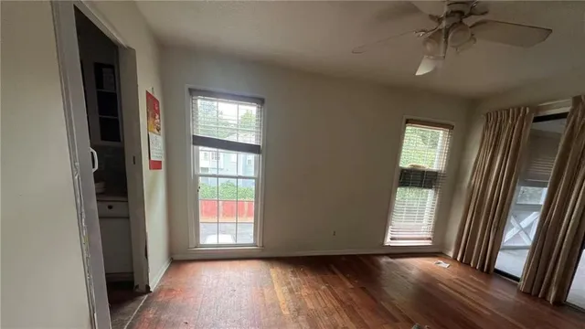 a view of hallway with window and wooden floor