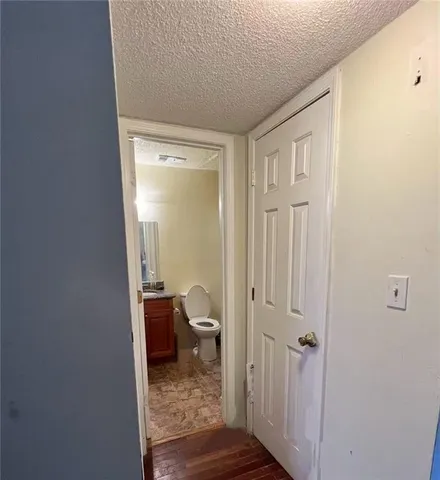 a bathroom with a granite countertop toilet sink and mirror