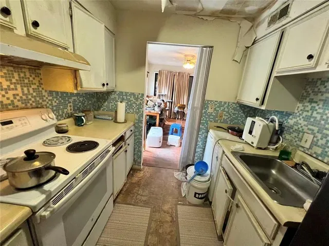a kitchen with a stove and a white cabinets