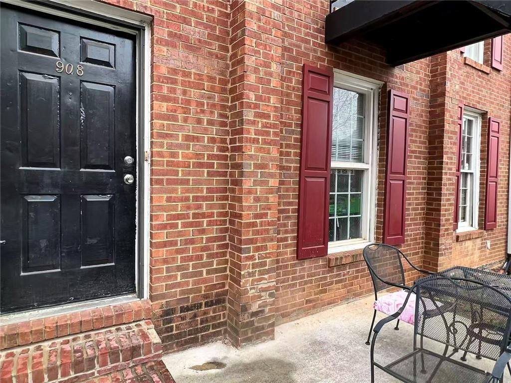 1166 Booth Road Southwest, Unit 908 Marietta, GA 30008 - Photo 29 of 32 a view of a brick house with a chairs and table in a patio