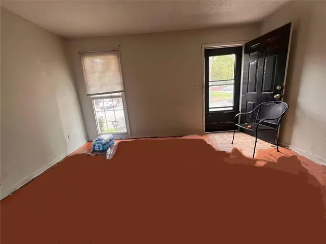 a bedroom with a bed table chair and window