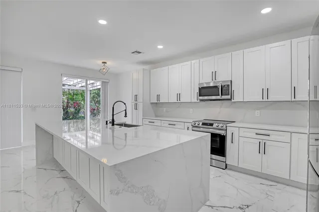 a utility room with stainless steel appliances washer and dryer