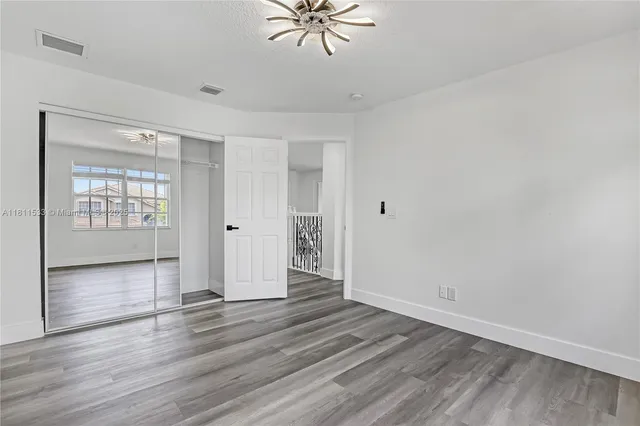 a front view of a house with a yard and potted plants