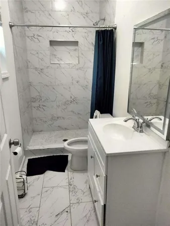 a bathroom with a sink toilet a mirror and shower