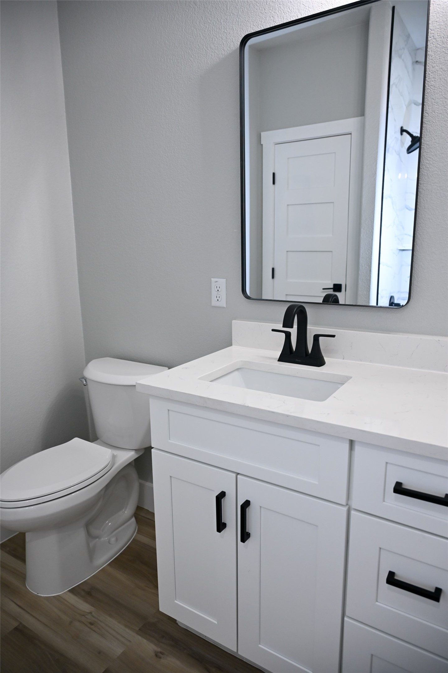 516 North Hackberry Avenue Luling, TX 78648 - Photo 13 of 36 Half bath with vanity and dark wood-style flooring