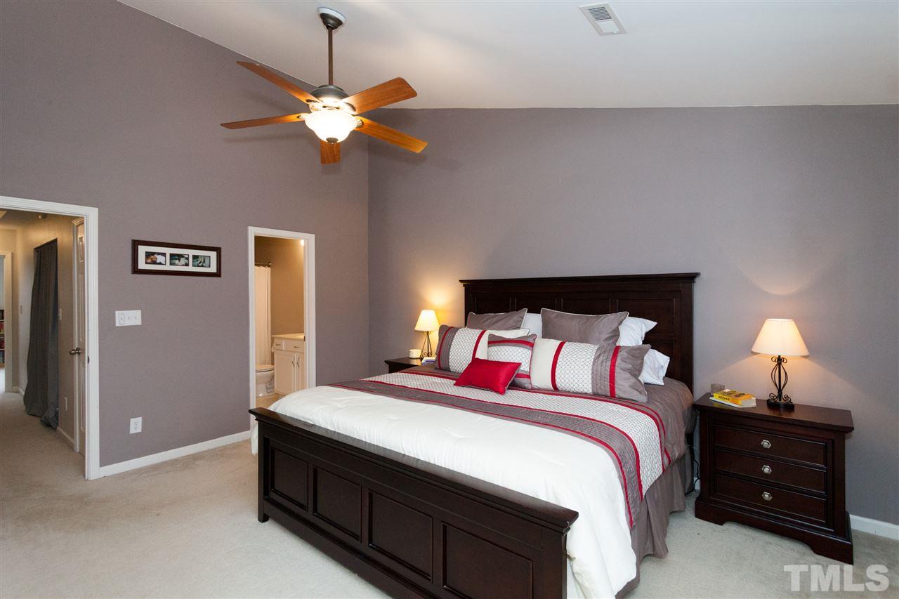 8456 Central Drive Raleigh, NC 27613 - Photo 4 of 25 a bedroom with a bed and a chandelier
