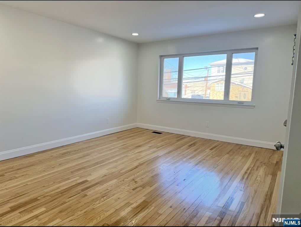 119 Bergen Street Harrison, NJ 07029 - Photo 2 of 13 wooden floor in an empty room with a window