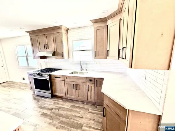 a kitchen with stainless steel appliances granite countertop a sink and a stove