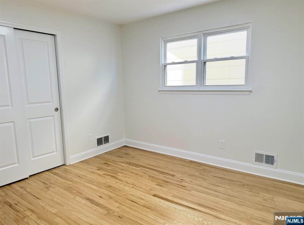 119 Bergen Street Harrison, NJ 07029 - Photo 8 of 13 an empty room with wooden floor and windows