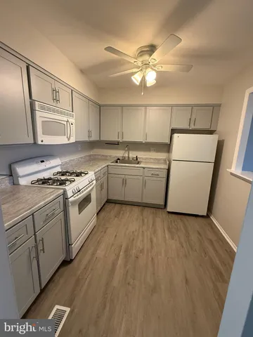 a kitchen with granite countertop a sink cabinets stainless steel appliances and a counter top space