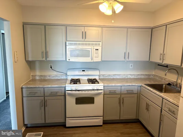 a kitchen with a stove sink and cabinets