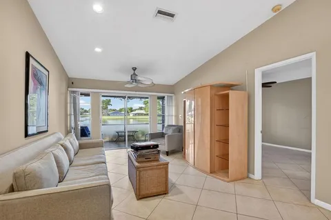 a living room with furniture a large window and stainless steel appliances
