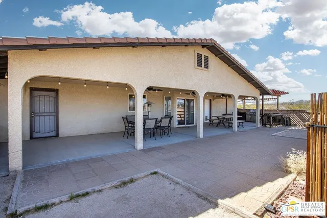a front view of a house with a large tree