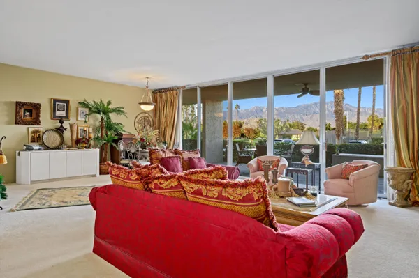 a living room with furniture and a floor to ceiling window