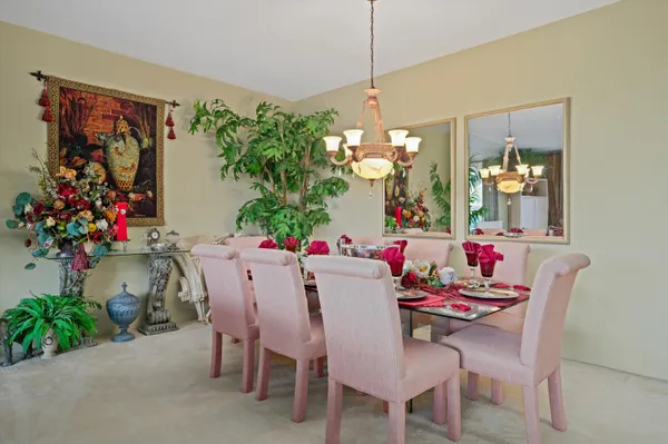a dining room with furniture potted plants and a chandelier