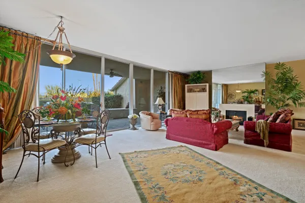 a living room with patio furniture and a potted plant