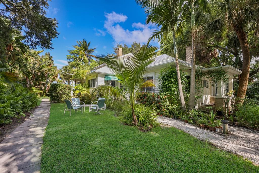 3301 Bay Shore Road Sarasota, FL 34234 - Photo 16 of 51 a view of a white house with a big yard and potted plants